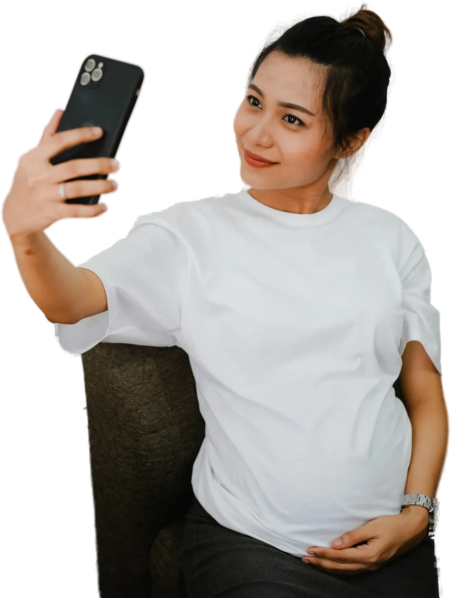 Pregnant woman taking a selfie with her hand on her bump
